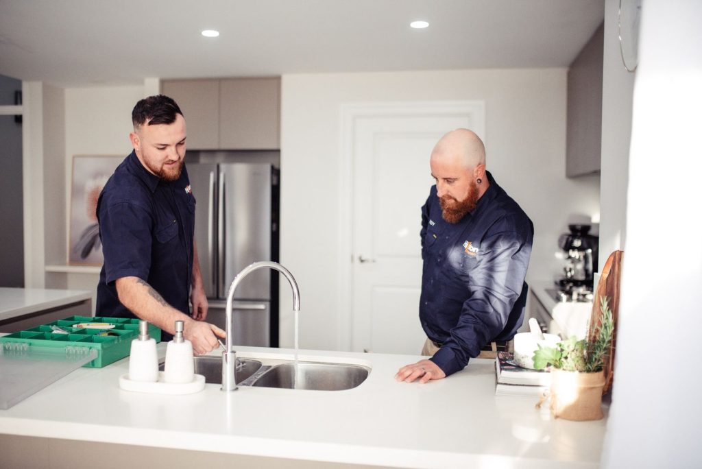 Plumbers repairing sink in Bellevue