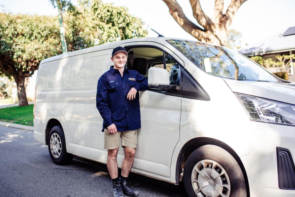 Plumber posing next to a car in Hammond Park